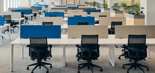 Modern open-plan office space featuring clean workstations, ergonomic chairs, and sanitized carpets provided by professional office cleaning services in Manchester, NH.